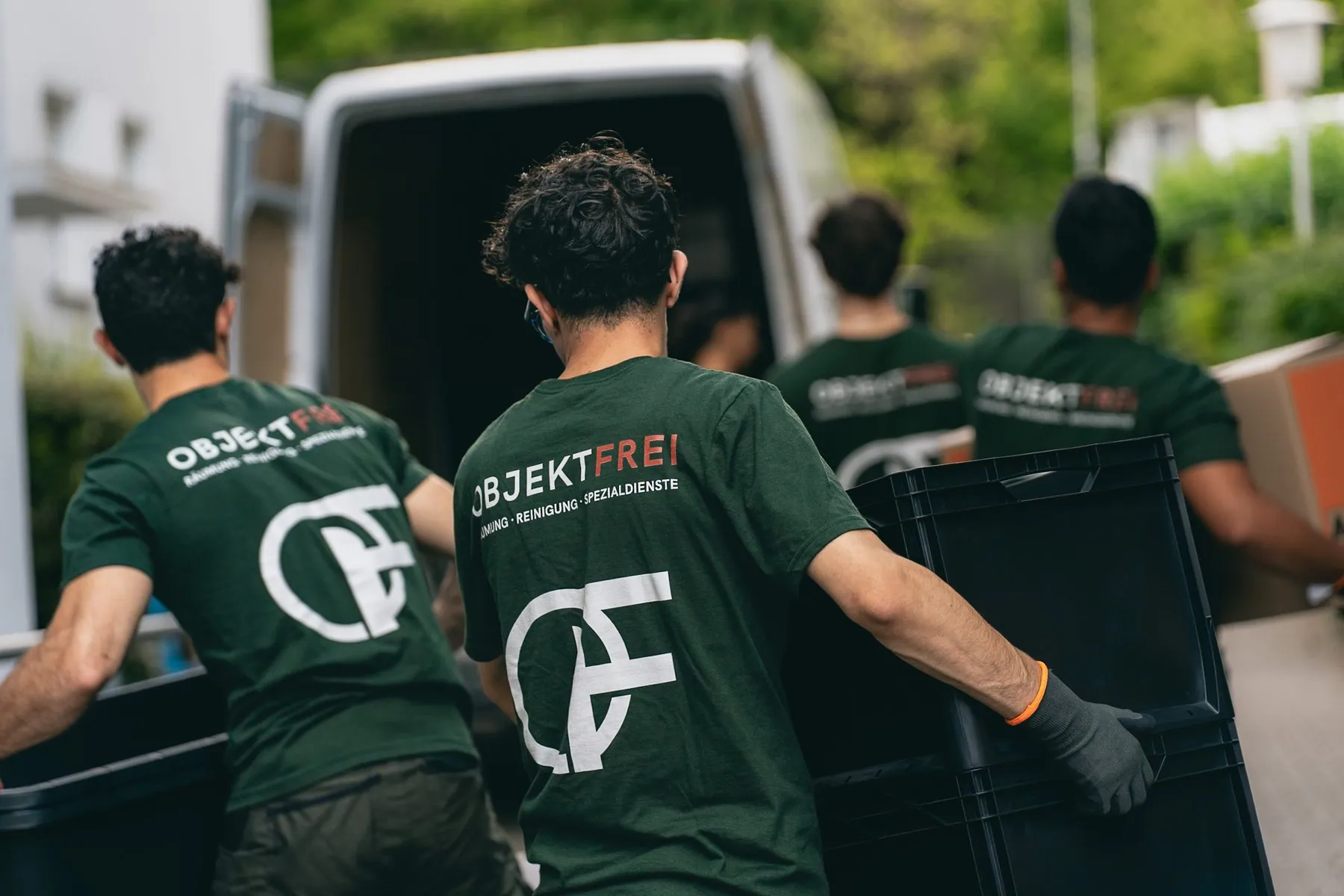 Das Objektfrei-Team trägt Transportkisten zum Transporter